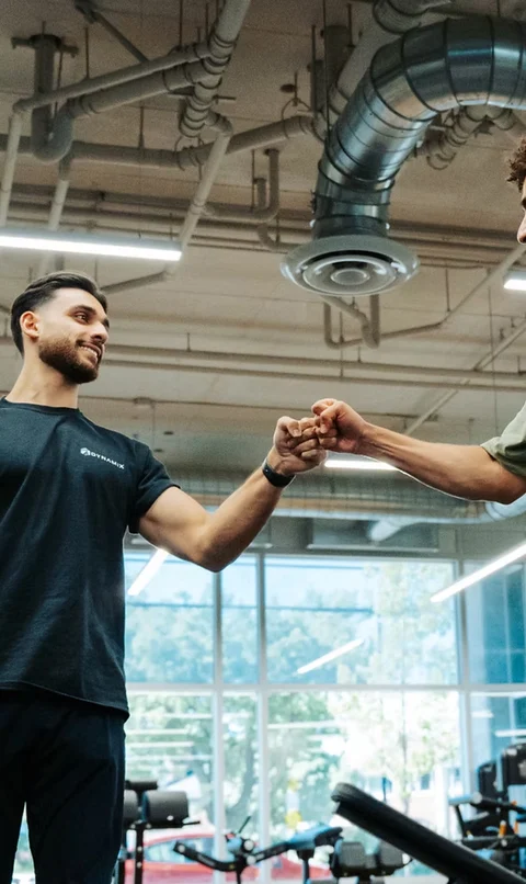 Two people sharing a fist bump in the Dynamix gym
